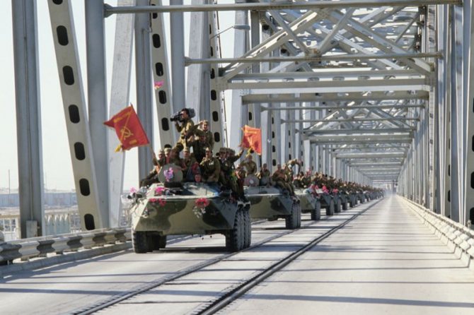 Колонна бронетехники пересекает афгано-советскую границу по мосту Дружбы через реку Амударью.