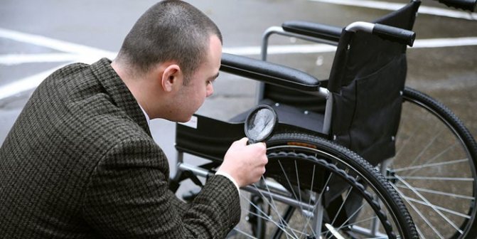 Мужчина осматривает инвалидную коляску